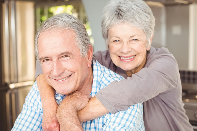 senior woman with her arms wrapping around her husband